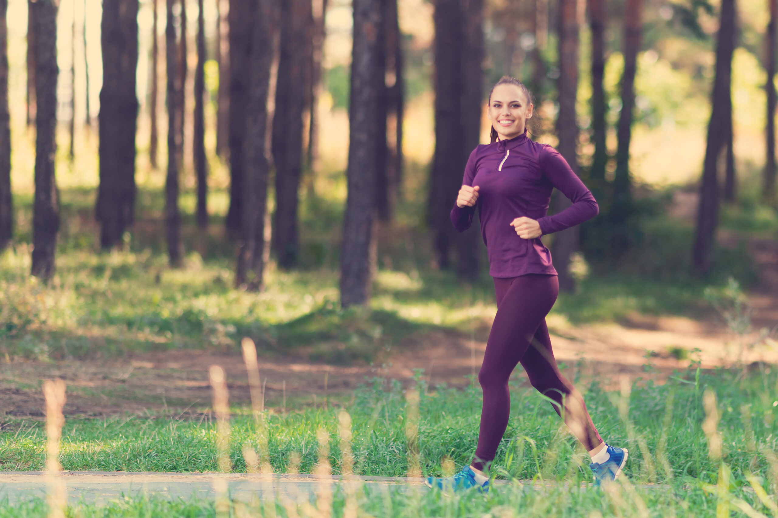 Woman powerwalking/running in park trail